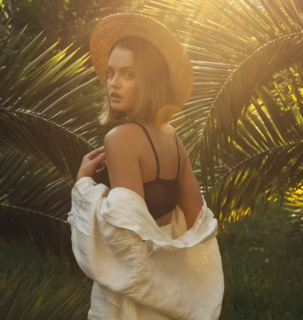 Woman in a straw hat looking back over her shoulder